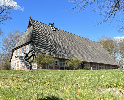 Das Heimathaus Rotenburg bei Sonnenschein mit grüner Wiese